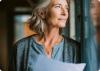 Frau haelt Blatt mit Diagnose in der Hand